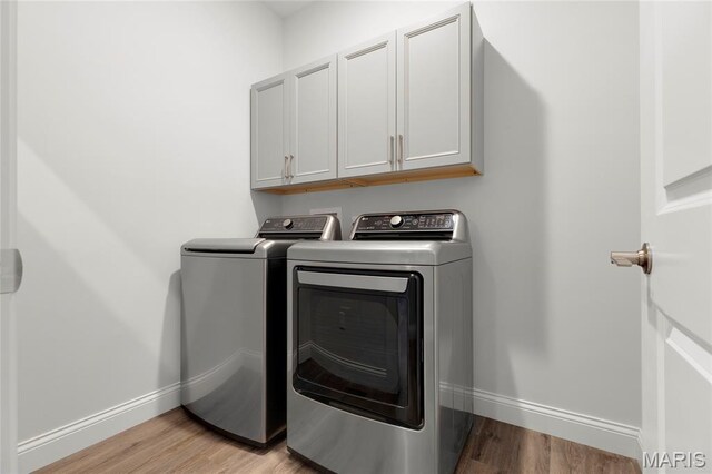 145 Royal Inverness Pkwy, Dardenne Prairie, MO 63368 - washroom with washing machine and clothes dryer, cabinet space, and light wood-type flooring