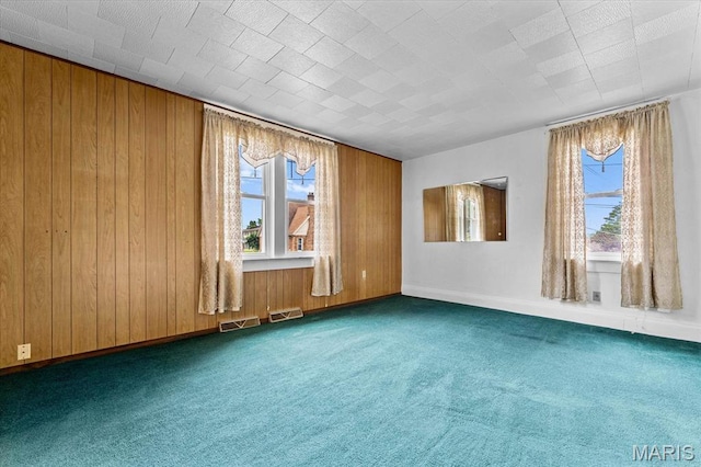 542 S Main St, Waterloo, IL 62298 - empty room featuring healthy amount of natural light, dark carpet, wooden walls, and baseboards