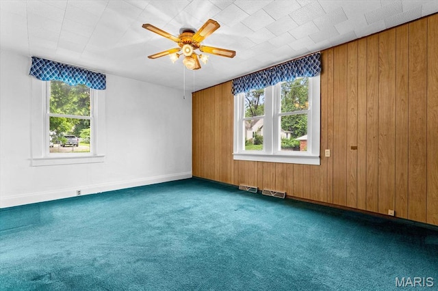 542 S Main St, Waterloo, IL 62298 - unfurnished room featuring carpet, a ceiling fan, wood walls, and baseboards