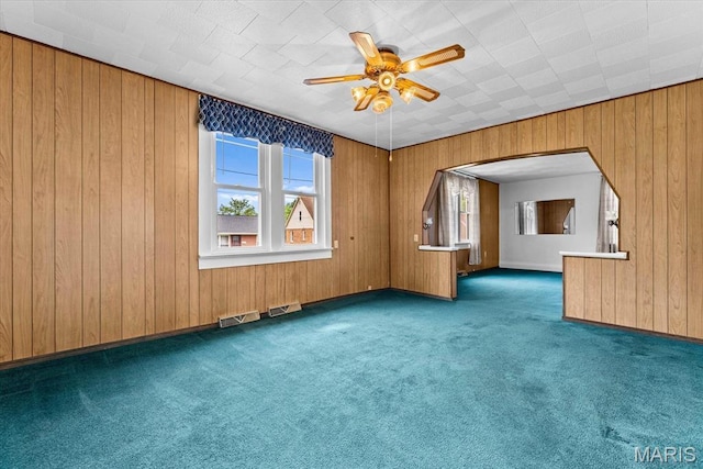 542 S Main St, Waterloo, IL 62298 - carpeted empty room featuring ceiling fan, arched walkways, and wooden walls