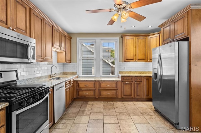 542 S Main St, Waterloo, IL 62298 - kitchen with appliances with stainless steel finishes, a sink, brown cabinets, backsplash, and light stone countertops