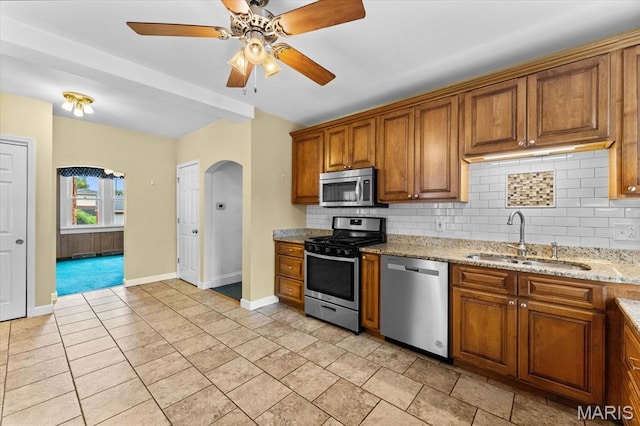 542 S Main St, Waterloo, IL 62298 - kitchen featuring stainless steel appliances, a sink, backsplash, and brown cabinetry