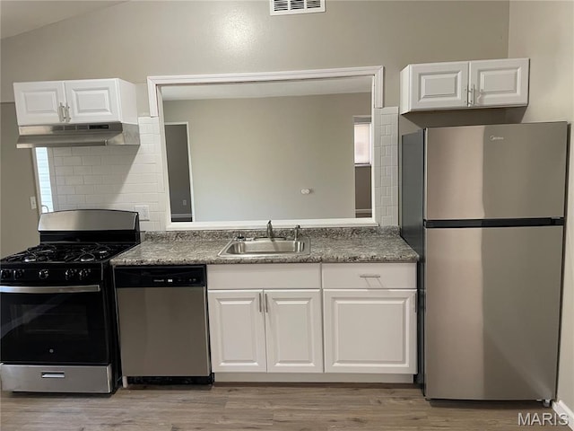 415 Waterford Dr, Florissant, MO 63033 - kitchen featuring stainless steel appliances, under cabinet range hood, tasteful backsplash, light wood finished floors, and lofted ceiling