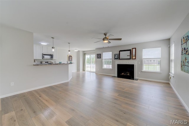 3325 Charlestowne Crossing Dr, Saint Charles, MO 63301 - unfurnished living room featuring ceiling fan, light wood-type flooring, and a fireplace