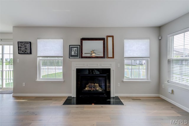 3325 Charlestowne Crossing Dr, Saint Charles, MO 63301 - living area featuring a fireplace with flush hearth, wood finished floors, and plenty of natural light