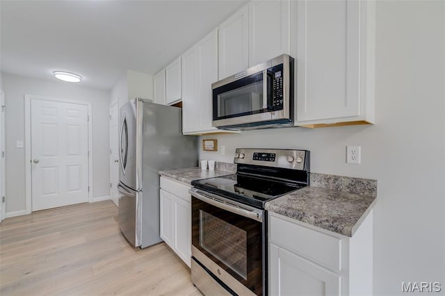3325 Charlestowne Crossing Dr, Saint Charles, MO 63301 - kitchen featuring appliances with stainless steel finishes, light wood-type flooring, and white cabinetry