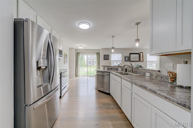 3325 Charlestowne Crossing Dr, Saint Charles, MO 63301 - kitchen with appliances with stainless steel finishes, white cabinetry, light wood-type flooring, pendant lighting, and a peninsula