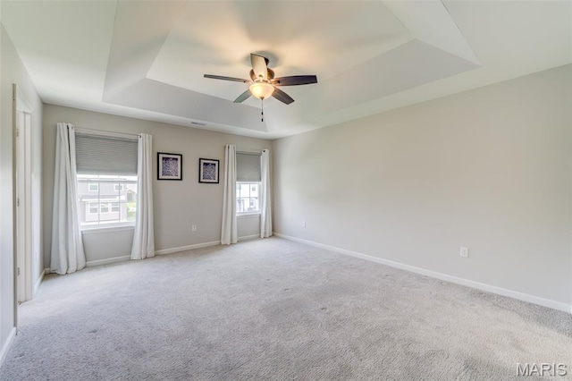 3325 Charlestowne Crossing Dr, Saint Charles, MO 63301 - spare room featuring a tray ceiling, a ceiling fan, and light colored carpet