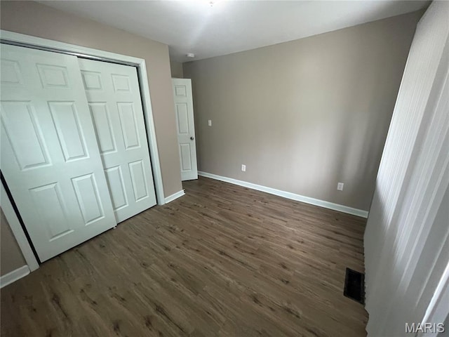 6155 Emerald Ave, Saint Louis, MO 63135 - unfurnished bedroom with dark wood-style floors and a closet