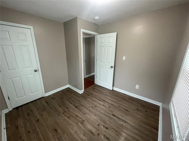 6155 Emerald Ave, Saint Louis, MO 63135 - unfurnished bedroom with baseboards and dark wood-style floors