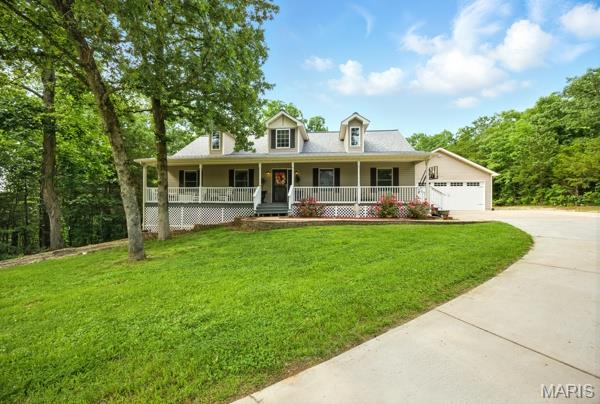 9 Sun Trail, Rise Trail, MO 63050 - view of front facade featuring a porch, driveway, a front yard, and a garage