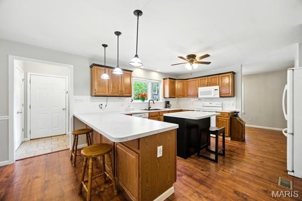 9 Sun Trail, Rise Trail, MO 63050 - kitchen featuring white appliances, brown cabinetry, a breakfast bar, and light countertops