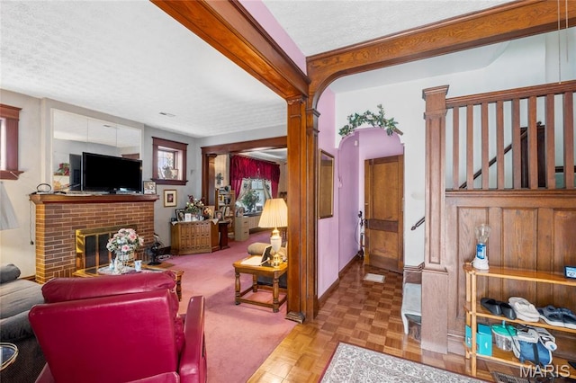 3623 Iowa Ave, Saint Louis, MO 63118 - living room featuring a textured ceiling, arched walkways, and a brick fireplace