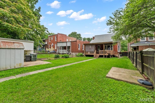 3623 Iowa Ave, Saint Louis, MO 63118 - fenced backyard featuring a wooden deck, a storage unit, and a patio