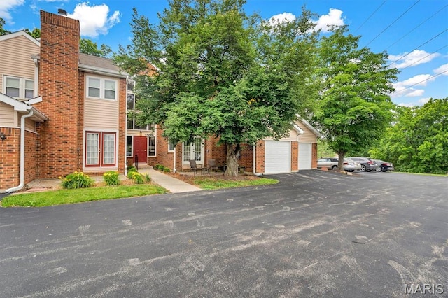 1308 Holgate Dr Unit G5, Ballwin, MO 63021 - view of front of house with brick siding, a garage, a chimney, and french doors