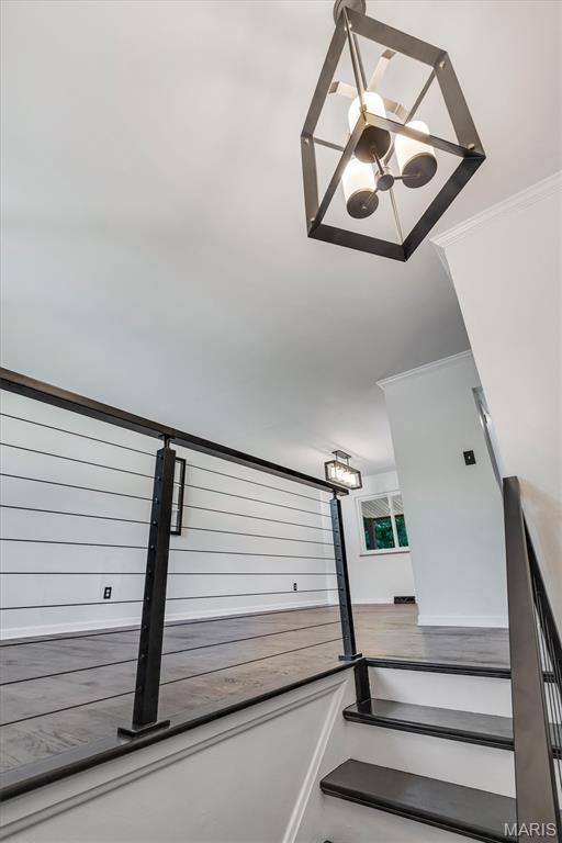 321 Fairview Ct, Ballwin, MO 63021 - staircase with ornamental molding and a chandelier