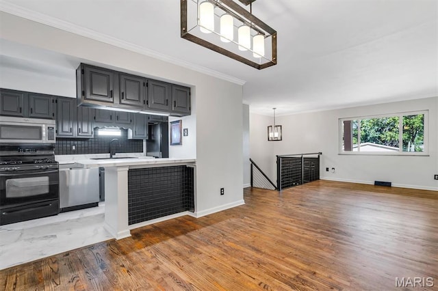 321 Fairview Ct, Ballwin, MO 63021 - kitchen with stainless steel appliances, light countertops, light wood-style floors, ornamental molding, and backsplash