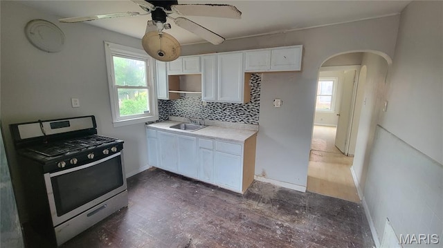1938 Damato Ct, Jennings, MO 63136 - kitchen with gas range, healthy amount of natural light, arched walkways, and tasteful backsplash