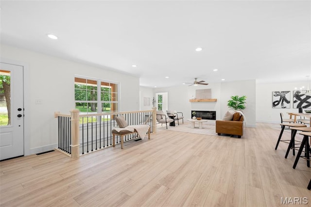 178 Spring Branch Rd, Troy, MO 63379 - living room featuring light wood-style flooring, recessed lighting, a glass covered fireplace, a chandelier, and a ceiling fan