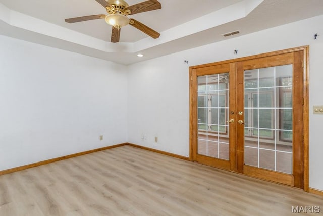 19395 Ripley Dr, Lebanon, MO 65536 - spare room featuring wood finished floors, french doors, a tray ceiling, baseboards, and a ceiling fan