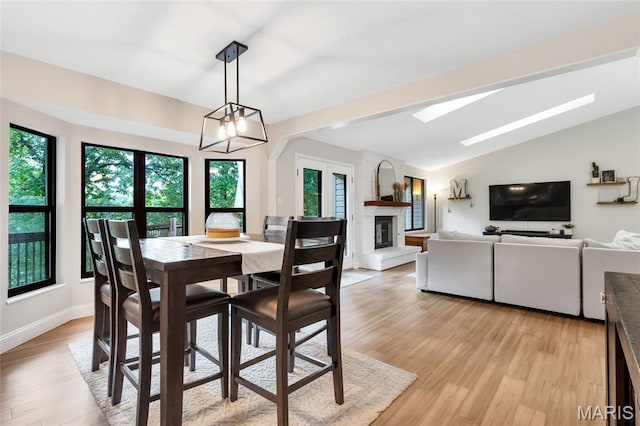 62 Majestic Ct, Fenton, MO 63026 - dining area featuring a skylight, light wood-style floors, a large fireplace, and vaulted ceiling