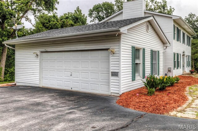 17560 Old Jamestown Rd, Florissant, MO 63034 - view of side of property with a chimney, asphalt driveway, and roof with shingles