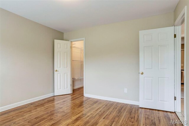 17560 Old Jamestown Rd, Florissant, MO 63034 - unfurnished bedroom featuring wood finished floors, baseboards, and a spacious closet