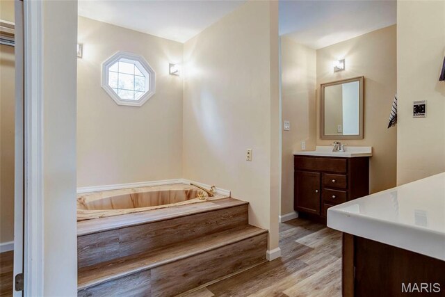 17560 Old Jamestown Rd, Florissant, MO 63034 - bathroom with vanity, a bath, wood finished floors, and baseboards