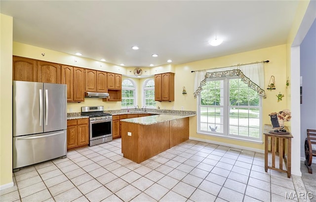 4 Hahn Estates Rd, Winfield, MO 63389 - kitchen with appliances with stainless steel finishes, under cabinet range hood, a peninsula, light tile patterned flooring, and recessed lighting