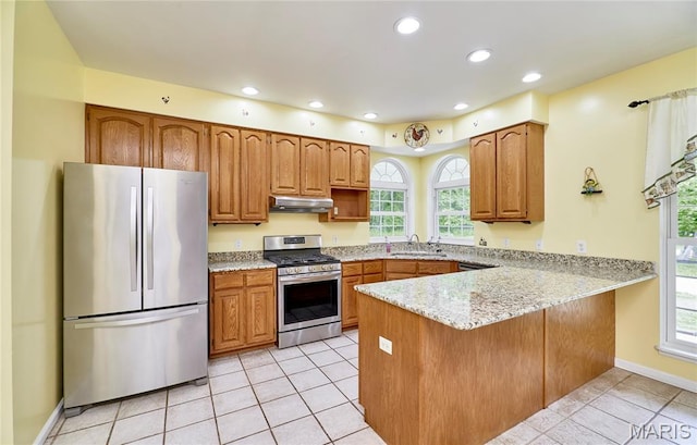 4 Hahn Estates Rd, Winfield, MO 63389 - kitchen with stainless steel appliances, under cabinet range hood, a peninsula, brown cabinets, and recessed lighting