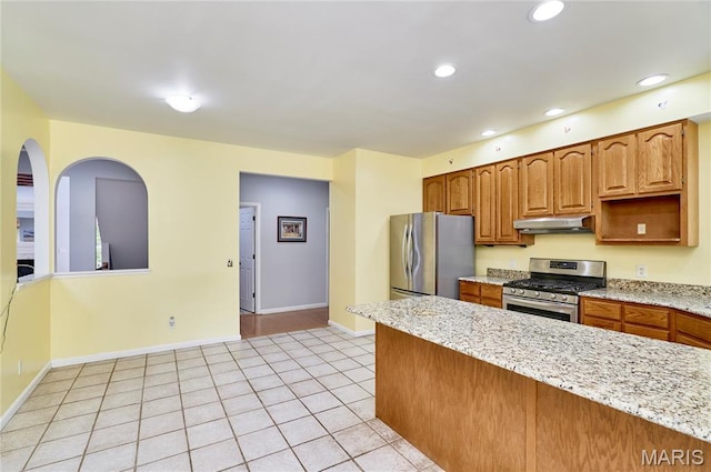 4 Hahn Estates Rd, Winfield, MO 63389 - kitchen with appliances with stainless steel finishes, under cabinet range hood, light tile patterned floors, recessed lighting, and light stone countertops
