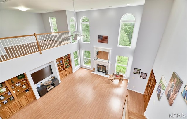 4 Hahn Estates Rd, Winfield, MO 63389 - living area with a towering ceiling, a fireplace, wood finished floors, built in shelves, and a ceiling fan