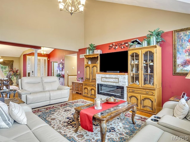 4184 Red Field Dr, Swansea, IL 62226 - living area with a chandelier, high vaulted ceiling, light wood finished floors, and a glass covered fireplace