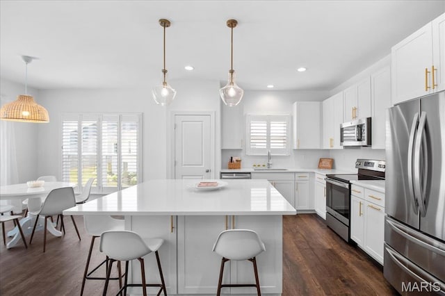 111 Creek Haven Ct, Lake St Louis, MO 63367 - kitchen featuring appliances with stainless steel finishes, a sink, a breakfast bar, a center island, and dark wood-style floors