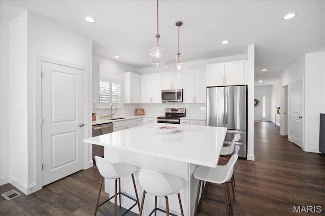 111 Creek Haven Ct, Lake St Louis, MO 63367 - kitchen featuring stainless steel appliances, a sink, a kitchen breakfast bar, dark wood-style flooring, and recessed lighting