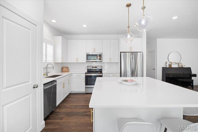 111 Creek Haven Ct, Lake St Louis, MO 63367 - kitchen with stainless steel appliances, a sink, dark wood-style flooring, a center island, and light countertops