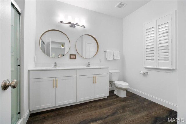 111 Creek Haven Ct, Lake St Louis, MO 63367 - bathroom with baseboards, double vanity, wood finished floors, toilet, and a shower with shower door