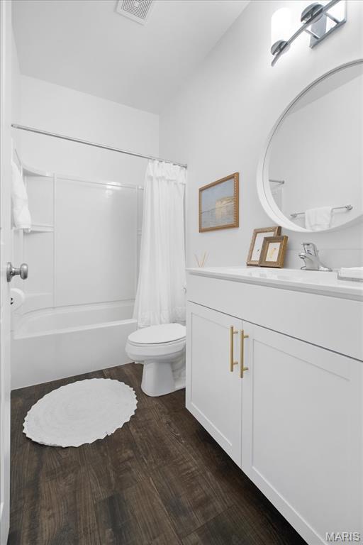 111 Creek Haven Ct, Lake St Louis, MO 63367 - bathroom with vanity, toilet, wood finished floors, and shower / bathtub combination with curtain