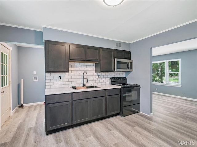 1216 Redman Blvd, Saint Louis, MO 63138 - kitchen featuring black / electric stove, stainless steel microwave, light wood-type flooring, backsplash, and ornamental molding