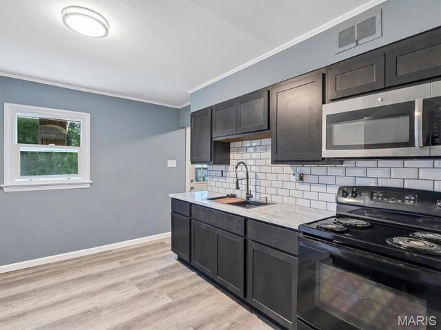 1216 Redman Blvd, Saint Louis, MO 63138 - kitchen featuring black electric range, stainless steel microwave, ornamental molding, tasteful backsplash, and light wood-style flooring