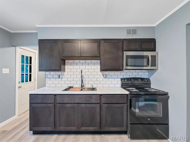 1216 Redman Blvd, Saint Louis, MO 63138 - kitchen featuring black / electric stove, stainless steel microwave, ornamental molding, dark brown cabinets, and light countertops