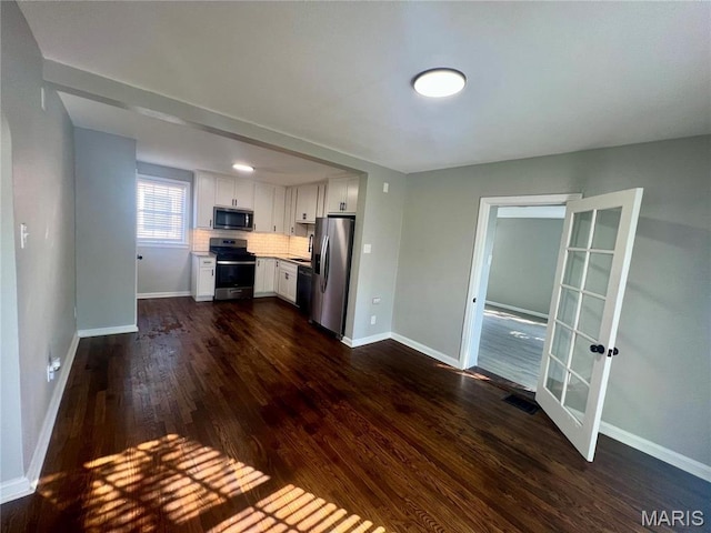 2328 Rockdale Ave, Saint Louis, MO 63121 - kitchen with stainless steel appliances, white cabinets, dark wood-type flooring, and baseboards