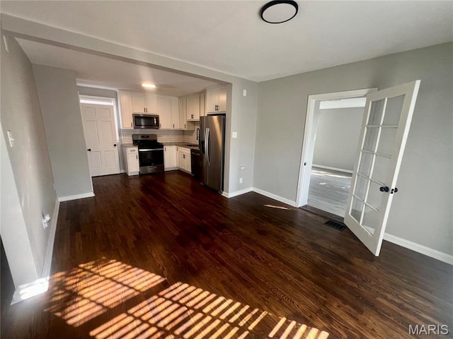 2328 Rockdale Ave, Saint Louis, MO 63121 - kitchen featuring appliances with stainless steel finishes, baseboards, dark wood-style flooring, white cabinets, and light countertops