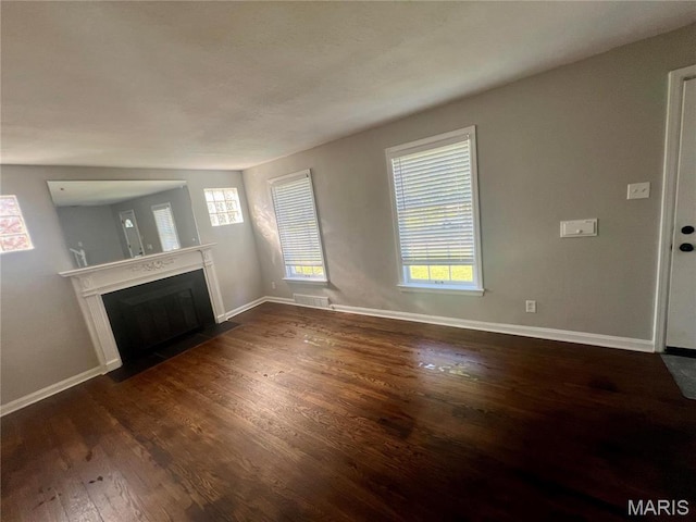 2328 Rockdale Ave, Saint Louis, MO 63121 - unfurnished living room with dark wood finished floors, baseboards, and a fireplace with flush hearth