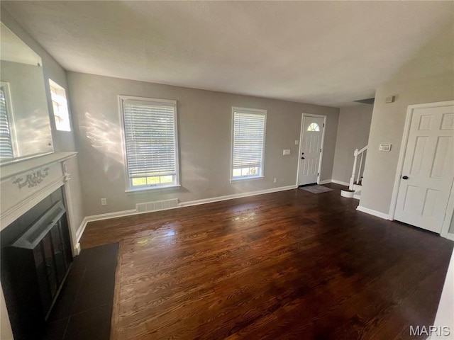 2328 Rockdale Ave, Saint Louis, MO 63121 - unfurnished living room featuring dark wood-style floors, a fireplace, baseboards, and stairs