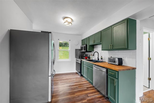 2604 Tamm Ave, Saint Louis, MO 63139 - kitchen with green cabinetry, appliances with stainless steel finishes, butcher block countertops, and decorative backsplash