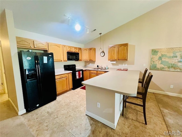 305 Hawk Nest Ct, Union, MO 63084 - kitchen featuring black appliances, a peninsula, light countertops, a breakfast bar, and track lighting
