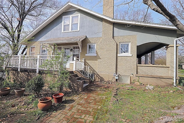 1425 Perryville Cpe, Girardeau, MO 63701 - rear view of property featuring a chimney, covered porch, brick siding, and stucco siding