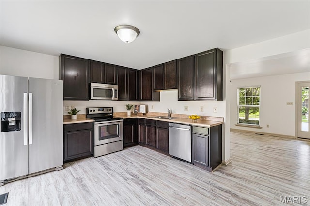 3101 Keelboat Xing, Saint Charles, MO 63301 - kitchen with appliances with stainless steel finishes, light countertops, light wood-type flooring, and dark brown cabinetry
