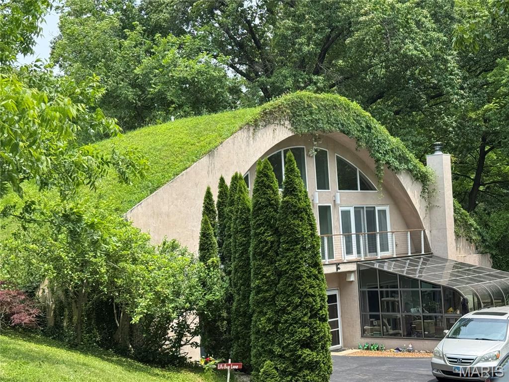 21 Charles Dr, Caseyville, IL 62232 - exterior space with stucco siding, a balcony, and a chimney